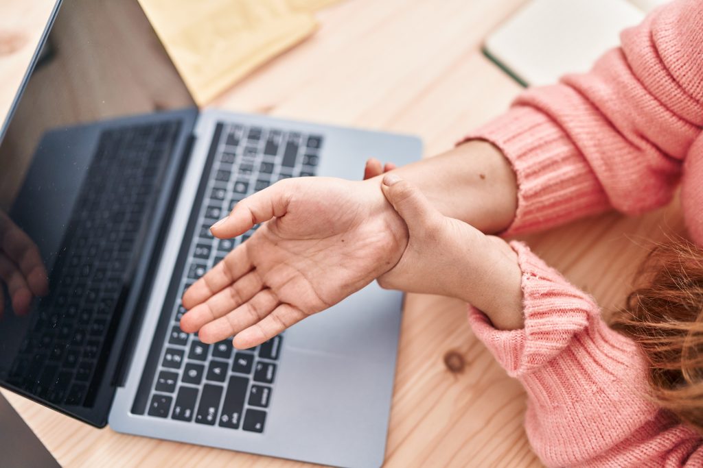 Young beautiful hispanic woman ecommerce business worker suffering for wrist pain at office