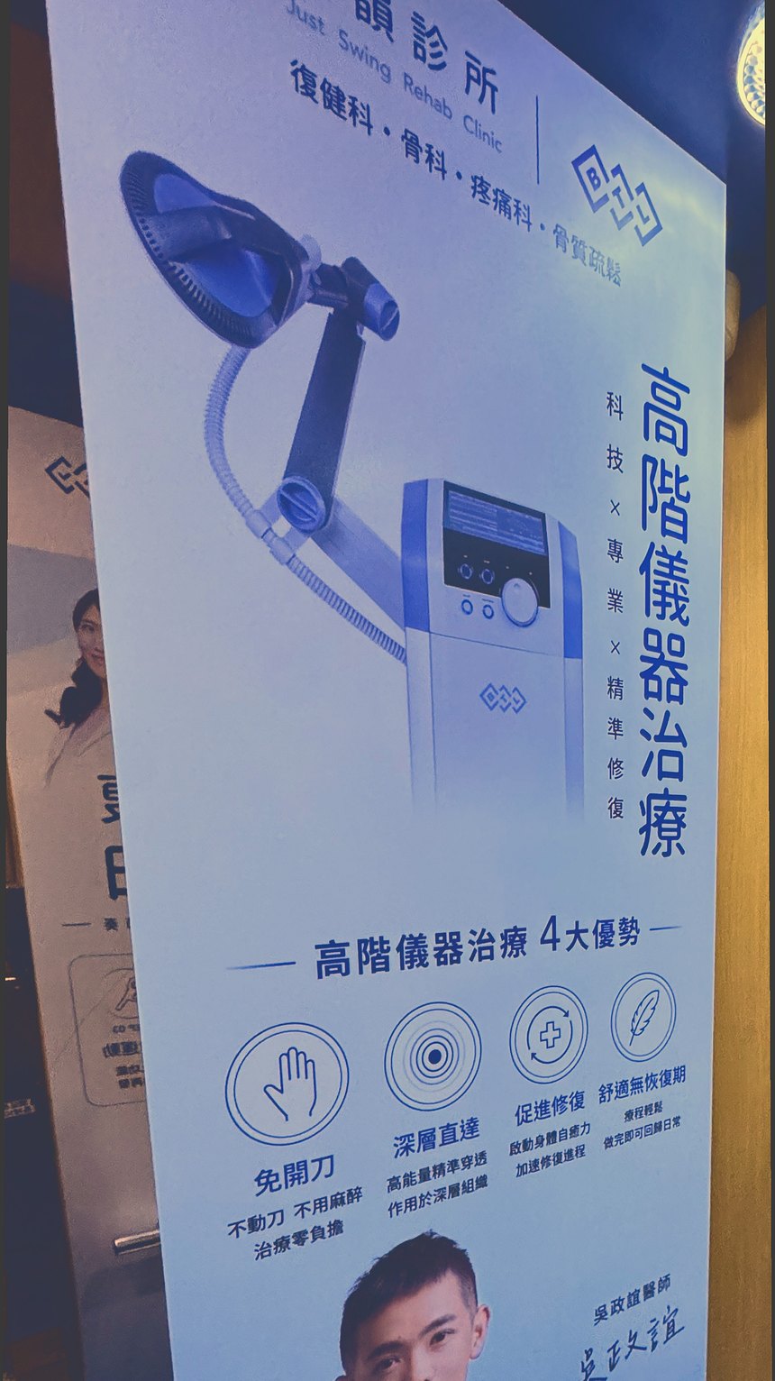嘉韻診所二樓電梯口的「高階儀器治療」直立式立牌現場照,牌面可見儀器照片、四項說明與吳政誼醫師署名