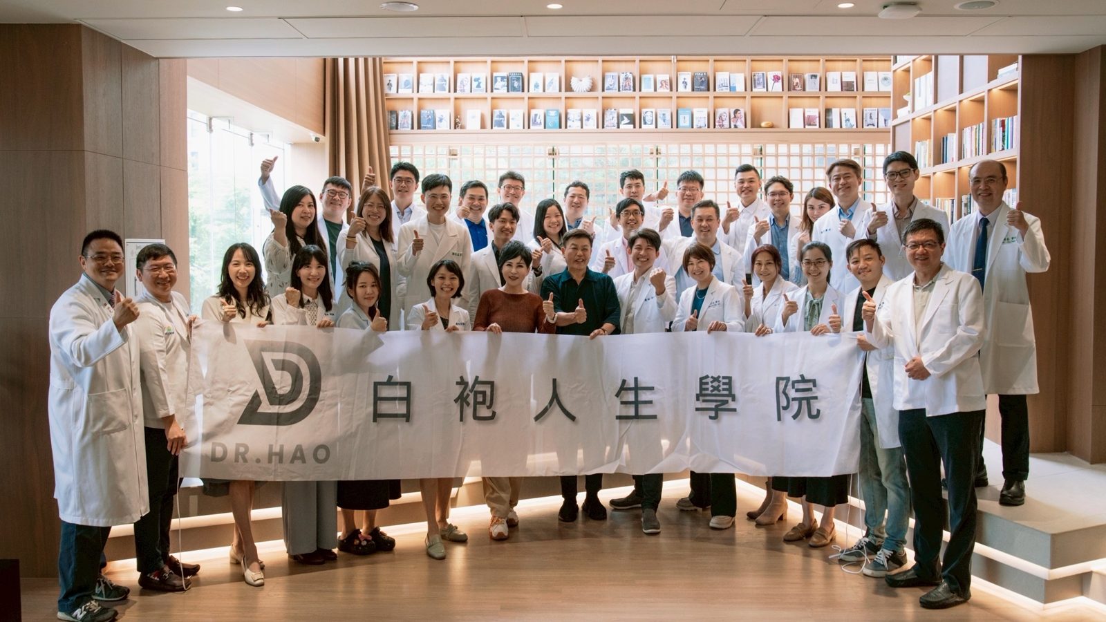 白袍人生學院參訪馬光中醫信義旗艦店的三十五位醫師與來賓,在書牆前拉起布條合影